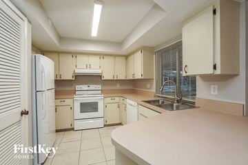 Cape Coral house for rent - a large kitchen with white appliances and white cabinets