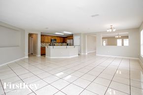 Poinciana house for rent - A spacious living room with a kitchen in the background.
