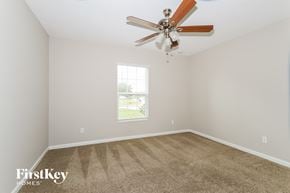 Port St. Lucie house for rent - a bedroom with carpet and a ceiling fan