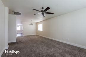 Houston house for rent - A spacious room with a ceiling fan and carpeted floor.