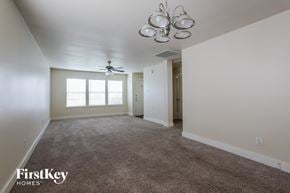 Houston house for rent - A spacious room with a carpeted floor and a ceiling fan.