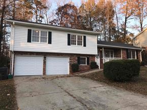 Snellville house for rent - a white and brick house with two garage doors