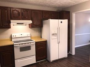 Snellville house for rent - a kitchen with white appliances and wooden cabinets and a refrigerator