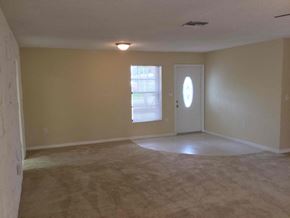 Miami Gardens house for rent - an empty living room with beige walls and a white door