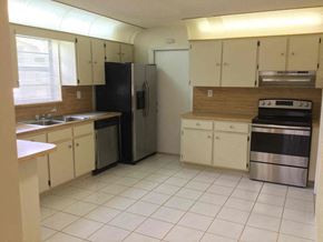 Miami Gardens house for rent - an empty kitchen with a stove refrigerator and sink