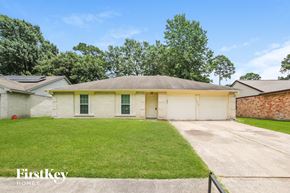 Humble house for rent - a white brick house with a lawn and a driveway