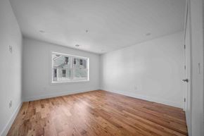 Paterson apartment for rent - the living room is spacious and has a large window and hardwood floors