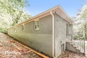 Smyrna house for rent - A small house with a brick exterior is surrounded by trees.