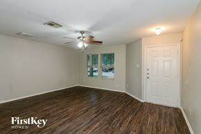 Cypress house for rent - A room with wooden floors and a ceiling fan.