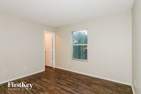 Cypress house for rent - A room with a door and a window with a view of trees.