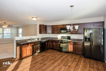 Kannapolis house for rent - a kitchen with wooden cabinets and stainless steel appliances