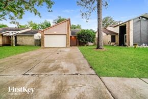 Cypress house for rent - an empty driveway in front of a house with a garage door