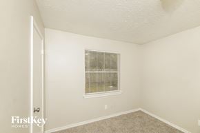 Cypress house for rent - a bedroom with white walls and carpet and a window
