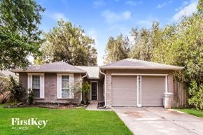 Houston house for rent - a small brick house with a driveway and a garage door