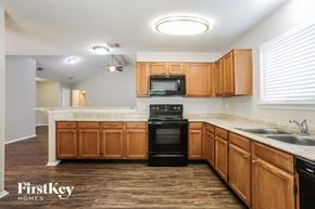 Houston house for rent - a kitchen with wooden cabinets and a black dishwasher