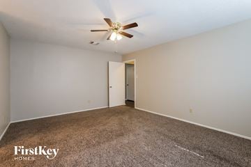 Houston house for rent - a spacious living room with carpet and a ceiling fan