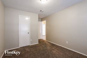 Houston house for rent - a bedroom with a carpeted floor and a door to a closet