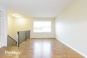 Lynwood house for rent - an empty living room with wood floors and white walls and a window