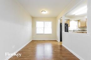 Lynwood house for rent - an empty living room and kitchen with wood flooring and a window
