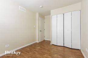 Lynwood house for rent - a bedroom with two white closets and a wooden floor