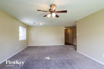 Humble house for rent - the spacious living room with carpet and ceiling fan