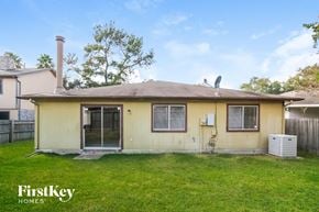 Humble house for rent - the front of a yellow house with a yard and grass