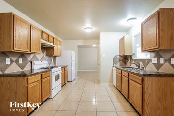 Humble house for rent - A kitchen with wooden cabinets and a tiled floor.