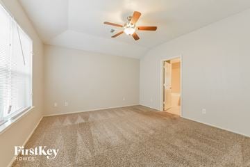 Humble house for rent - a spacious living room with carpet and a ceiling fan
