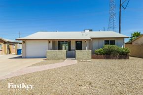 Chandler house for rent - a small white house with a driveway and a garage door