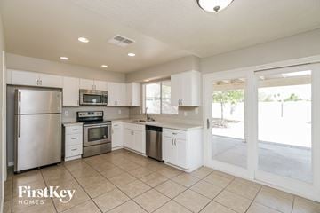 Chandler house for rent - a large kitchen with stainless steel appliances and white cabinets