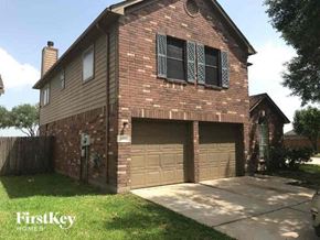 Missouri City house for rent - a brown brick house with two garage doors