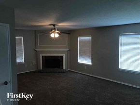 Missouri City house for rent - a living room with a fireplace and a ceiling fan