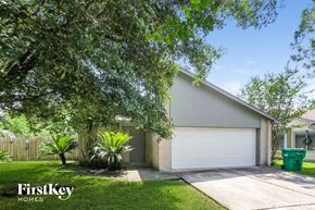 Humble house for rent - a home with a white garage door and green grass and trees