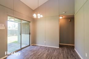 Humble house for rent - a living room with a large mirror and wood flooring