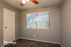 Humble house for rent - a bedroom with a large window and a ceiling fan