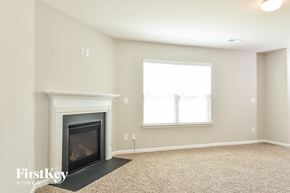 Whitsett house for rent - A living room with a fireplace and a window.