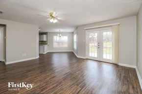 Corinth house for rent - A spacious room with wooden floors and a ceiling fan.
