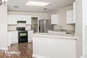 Corinth house for rent - A kitchen with white cabinets and a black oven.