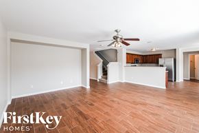 Grand Prairie house for rent - A spacious room with wooden flooring and a ceiling fan.