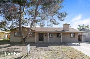Phoenix house for rent - a beige house with a tree and a driveway