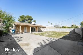 Phoenix house for rent - a small house with a driveway and a yard with grass