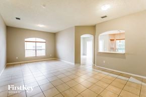 Homestead house for rent - an empty living room with tiled floors and a window