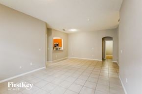 Homestead house for rent - a spacious living room with tiled floors and a hallway to the kitchen