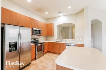 Homestead house for rent - a large kitchen with stainless steel appliances and white counter tops