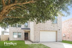 Cypress house for rent - a white brick house with a garage door and a tree