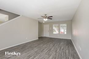 Cypress house for rent - the living room of an empty house with a ceiling fan