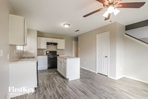 Cypress house for rent - a kitchen with white cabinets and a ceiling fan