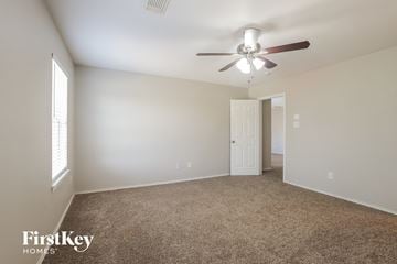 Cypress house for rent - a living room with carpet and a ceiling fan