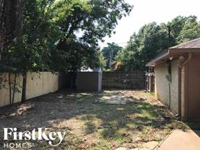 Arlington house for rent - a backyard with a fence and a yard with grass and trees