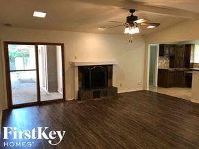 Arlington house for rent - an empty living room with a fireplace and a ceiling fan